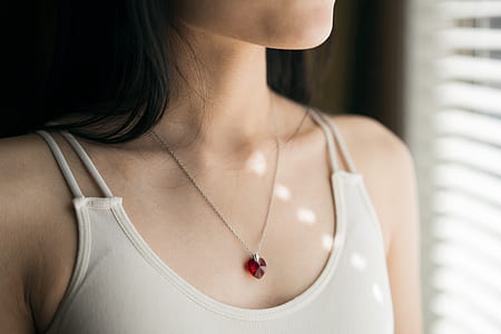 woman wearing white spaghetti strap top and red gemstone pendant necklace thumbnail
