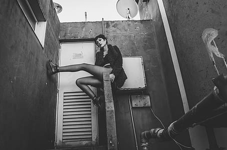 Woman in Fur Coat Sitting on Concrete Handrail thumbnail