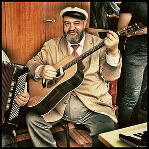 man sitting on chair playing guitar painting thumbnail