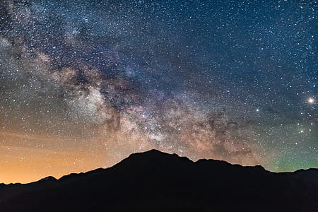 silhouette photograph of mountain under starry night sky thumbnail