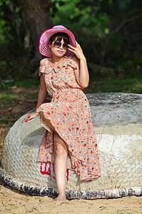 women's sitting on rock taking picture during daytime thumbnail
