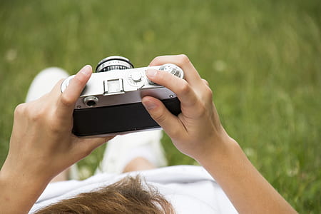 person holding gray and black camera body thumbnail