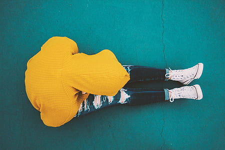 person in distressed jeans and yellow hoodie thumbnail