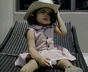 girl in pink dress sitting on black sun lounger thumbnail