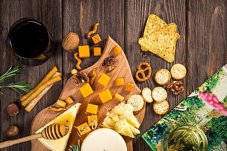 beige wooden cutting-board with vegetable cut into pieces on top and beige wooden honey ladle on wooden surface table thumbnail
