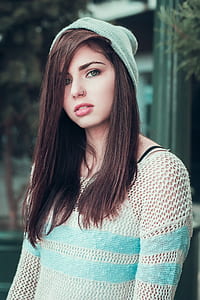 woman in white and blue knitted top wearing blue knit cap thumbnail