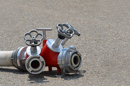 red and gray fire hose nozzle on gray concrete surface thumbnail