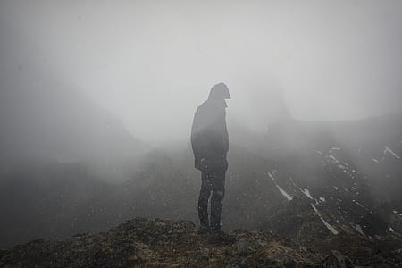 silhouette of person standing on mountain top during foggy day thumbnail
