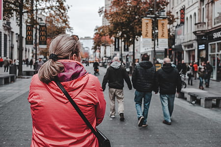 woman walking on street between buildings thumbnail
