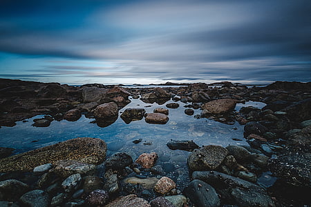 low-angle photography of rocks near body of water thumbnail