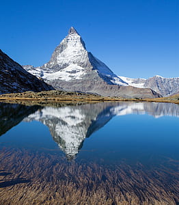 body of water near gray mountain thumbnail