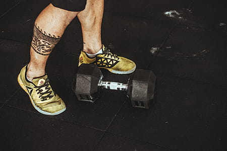 Person Wearing Pair of Gold-and-black Sneakers thumbnail