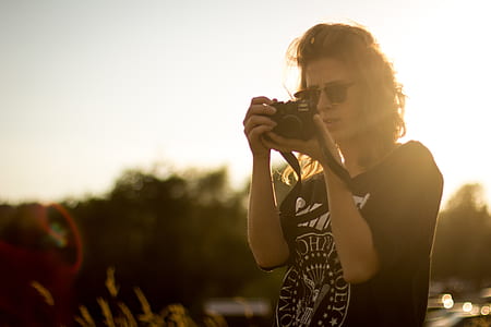 woman wearing black shirt looking on DSLR camera thumbnail