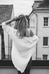 woman holds her hair at top of the building thumbnail