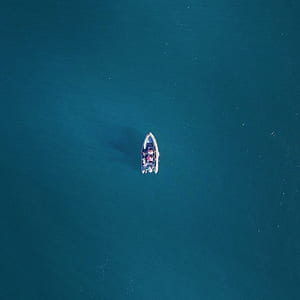 white inflatable boat in middle of body of water thumbnail