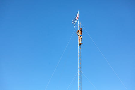 man standing on flag pole thumbnail