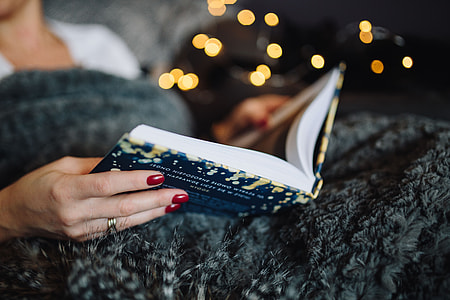 Young woman at home reading Hygge book and drinking thumbnail