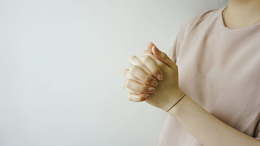 person clasping against white wall thumbnail