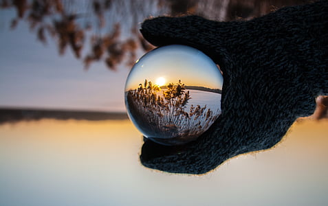 person holding clear glass ball showing the grass photography thumbnail