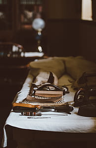 brown and gray tool on top of white linen thumbnail