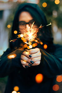 woman with black manicure holding sparklers thumbnail