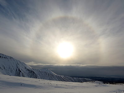snow-capped mountain with sun as background thumbnail