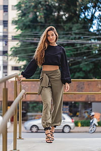 woman wearing black crop top and gray pants standing beside road thumbnail
