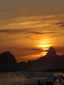 people on the side of the ocean during golden hour thumbnail