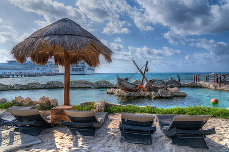 four black outdoor lounger chairs near body of water during daytime thumbnail