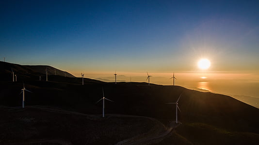 gray windmill on top on mountain under blue sky thumbnail