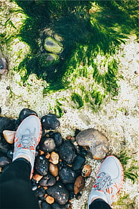 person standing on gray pebbles thumbnail