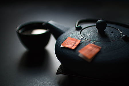 black ceramic teapot and teacup on black surface thumbnail