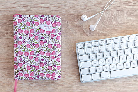 white earphones beside white computer keyboard thumbnail
