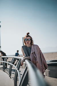 woman leaning beside black metal rail at daytime thumbnail