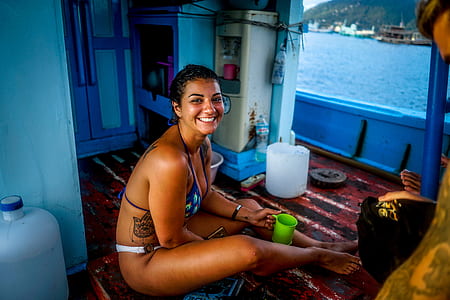 woman in bikini sitting on boat floor thumbnail