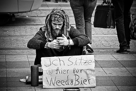 man sitting on road in front of signage thumbnail