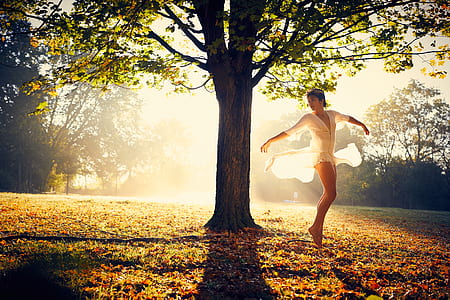 woman dancing near tree during daytime thumbnail