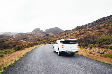 Blurry pick up truck passes on highway with mountains in the background thumbnail