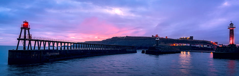 red lighthouse near bridge at blue hour thumbnail