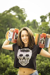 selective focus photography of woman carrying skateboard on her back thumbnail