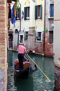 man holding paddle while riding on gondola thumbnail