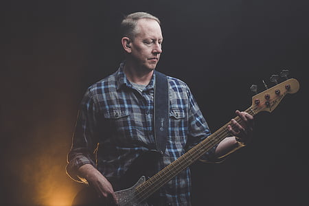 man playing electric guitar on dark area thumbnail