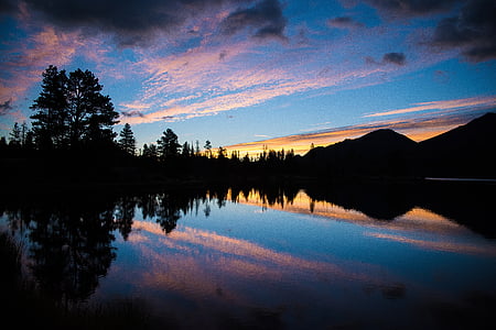 silhouette of trees and mountains during golden hour thumbnail