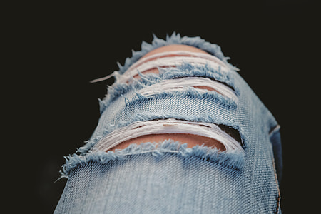 person wearing distressed blue denim bottoms thumbnail