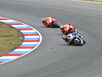 three person riding on sports bike while racing on track thumbnail