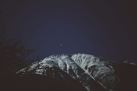 worm's eyeview photo of rocky mountain during night time thumbnail