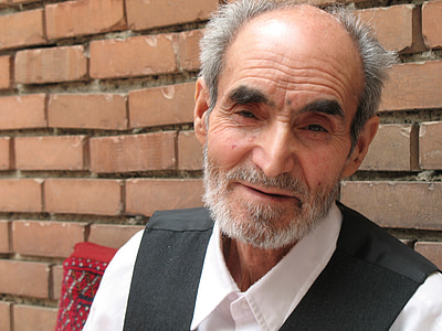 smiling man in white collared top wearing black vest thumbnail