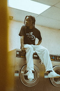 man sitting on gray front-load dryer thumbnail