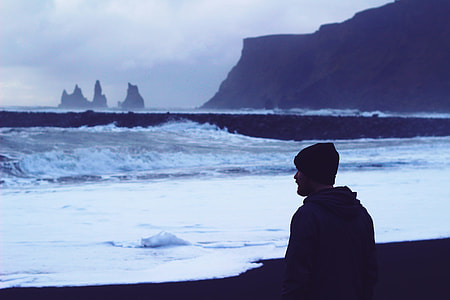 man wearing knit cap and jacket near body of water thumbnail