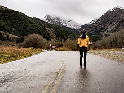 man standing on black asphalt road during daytime thumbnail